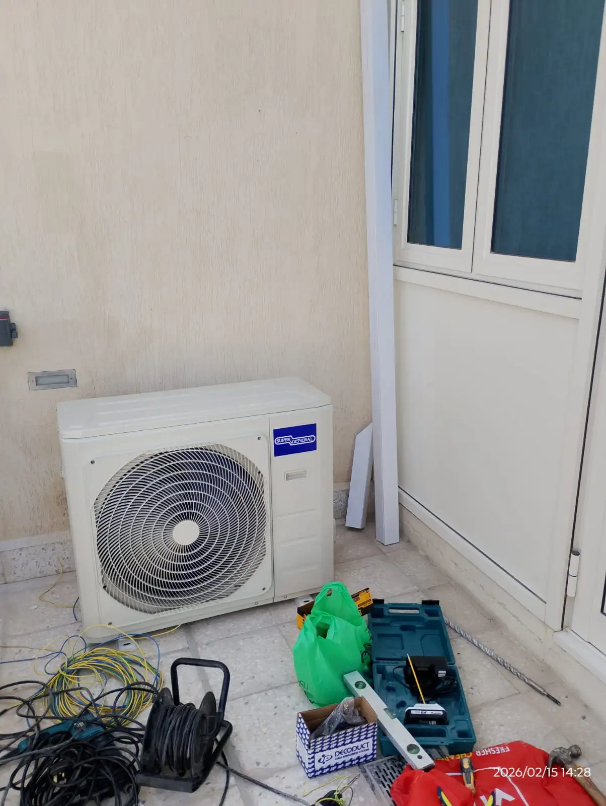 Technician installing a wall-mounted split AC unit in Dubai — supporting project view 1