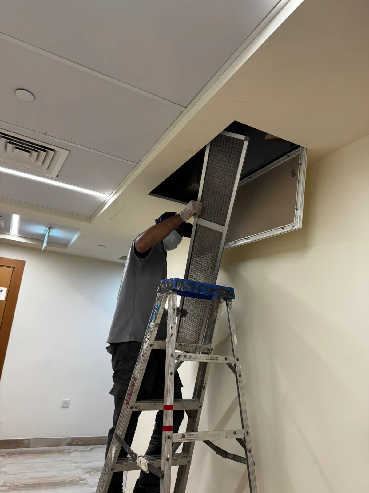 Technician checking an AC filter during maintenance in Dubai