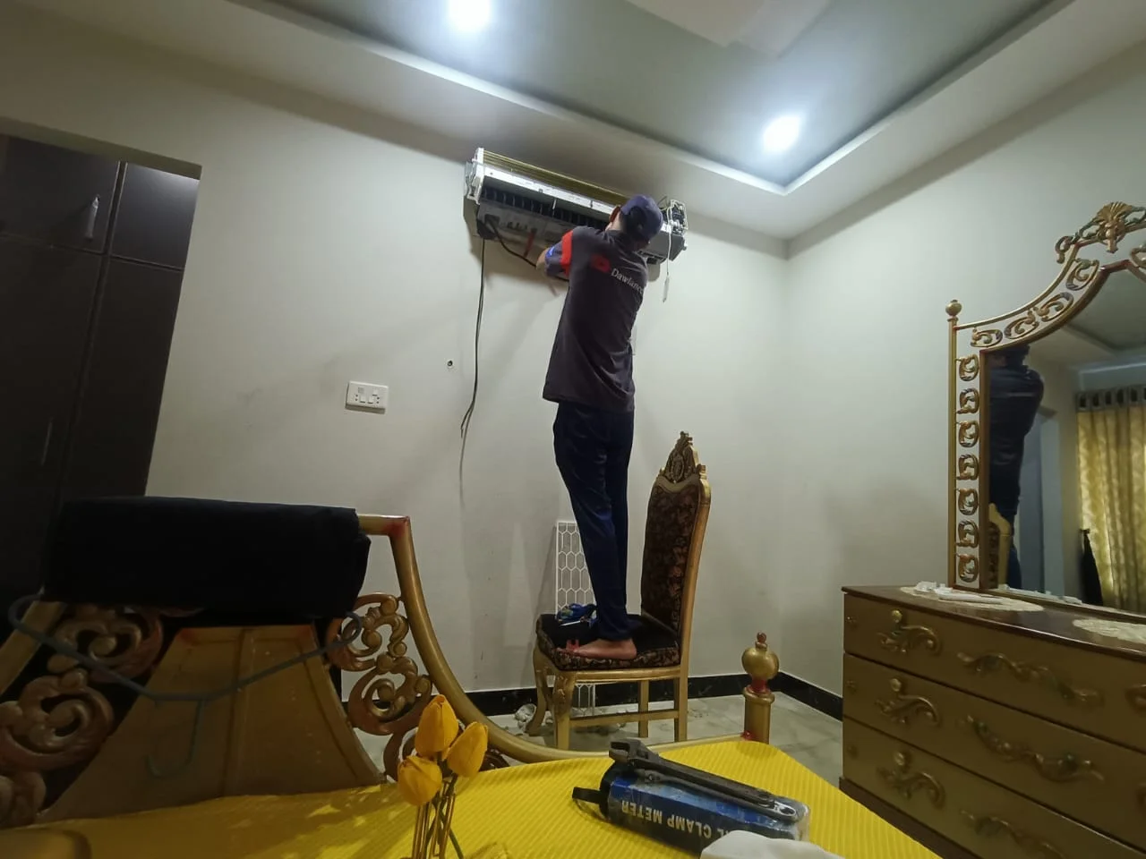 Technician servicing a wall-mounted split AC inside a Dubai home