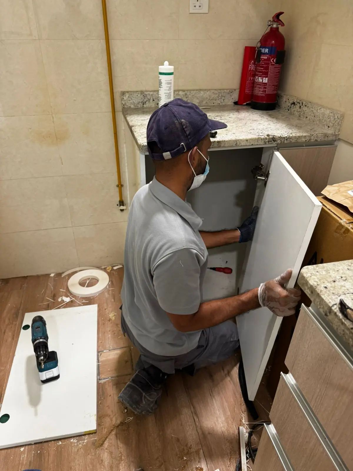 Technician repairing a kitchen cabinet panel in Dubai — supporting project view 3