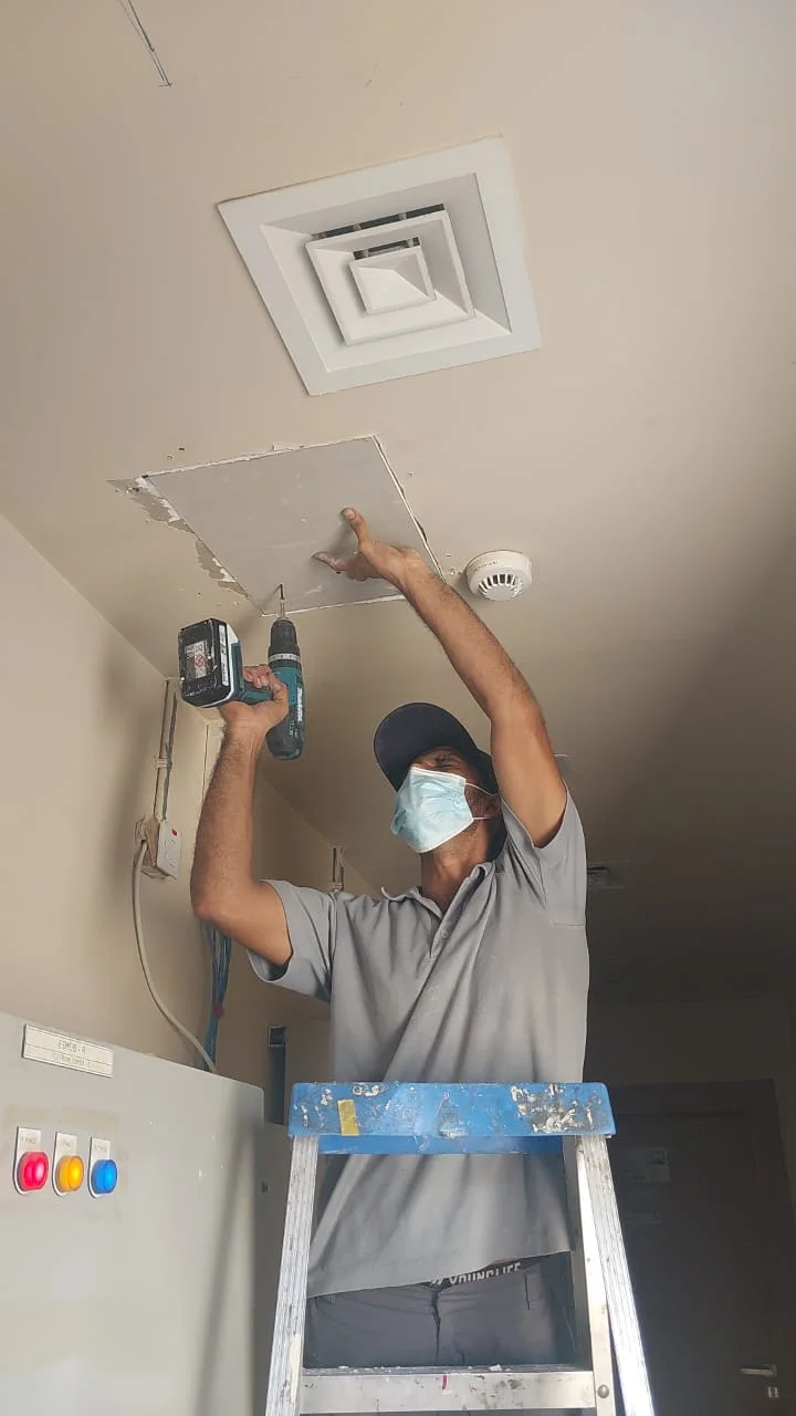 Technician carrying out a minor ceiling repair inside a Dubai property