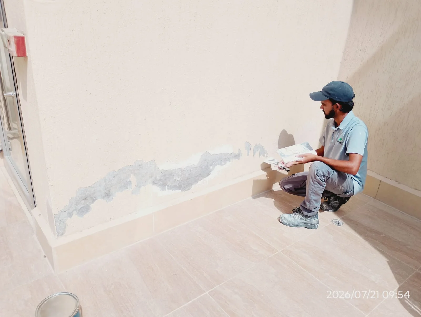 Handyman repairing a wall surface inside a Dubai home