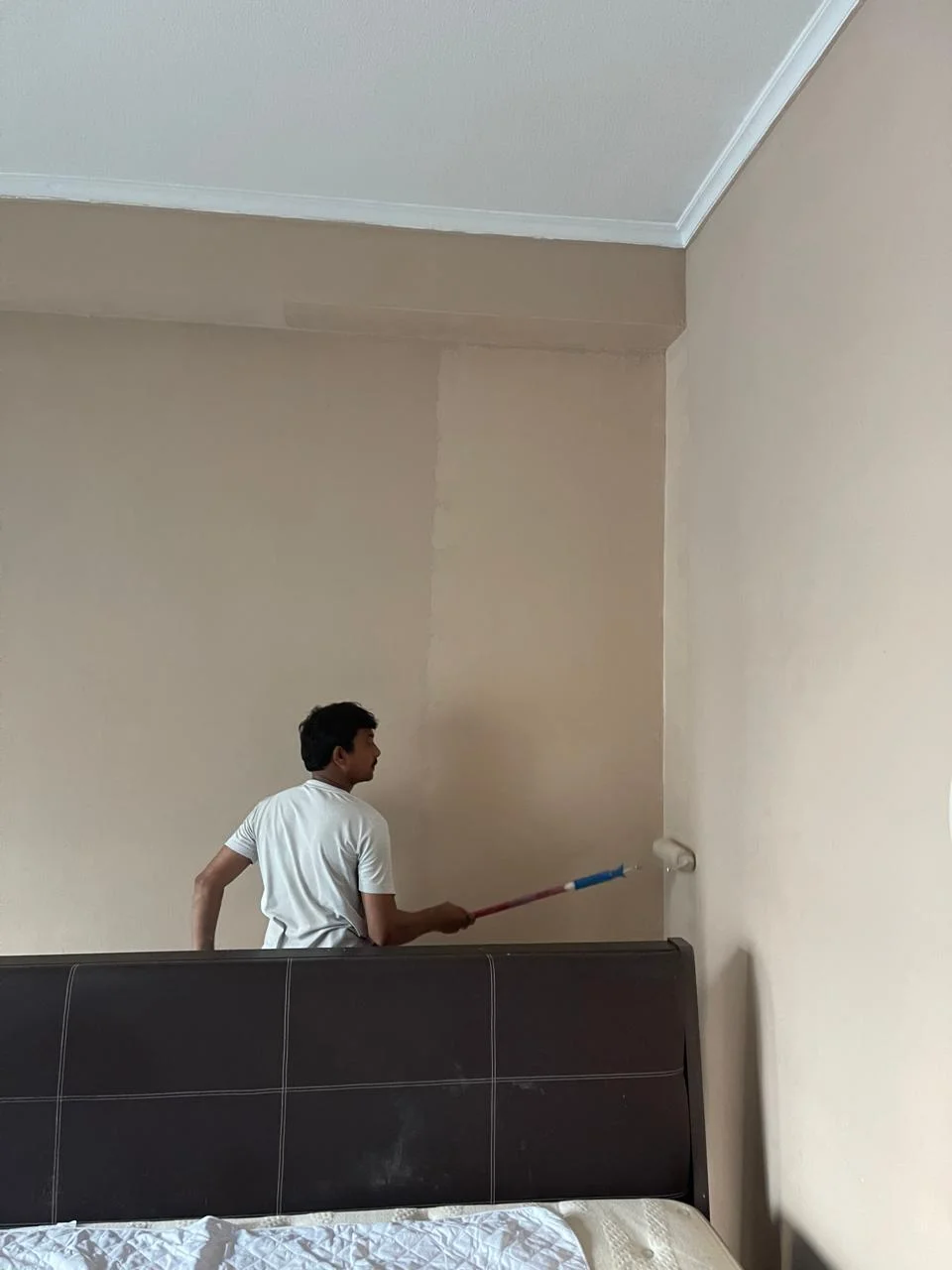 Painter applying wall paint in a Dubai apartment bedroom