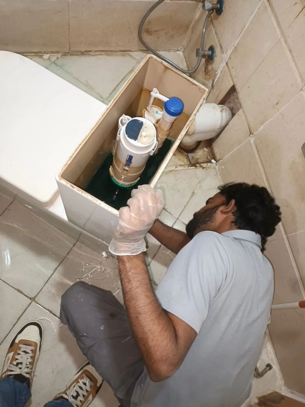 Plumber working beneath a kitchen sink in a Dubai home — supporting project view 1
