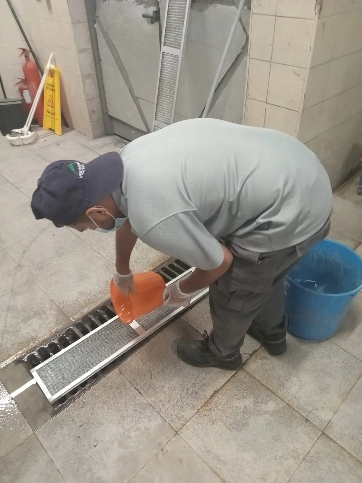 Technician cleaning a floor drain in a Dubai bathroom