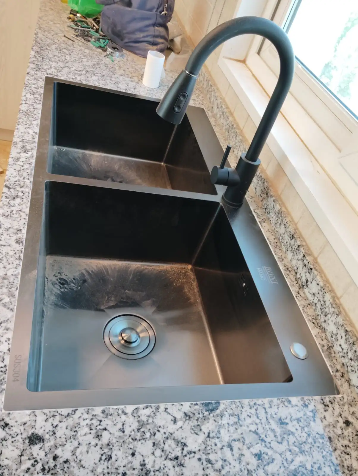 Technician repairing plumbing beneath a kitchen sink in Dubai — supporting project view 3