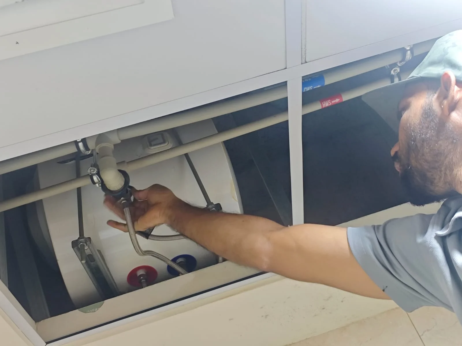 Plumber working beneath a kitchen sink in a Dubai home — supporting project view 3