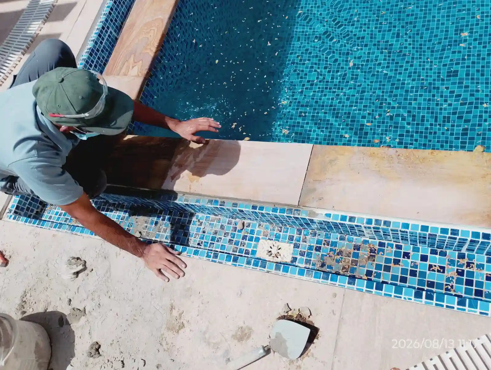 Technician repairing the tiled edge of a swimming pool in Dubai — supporting project view 1