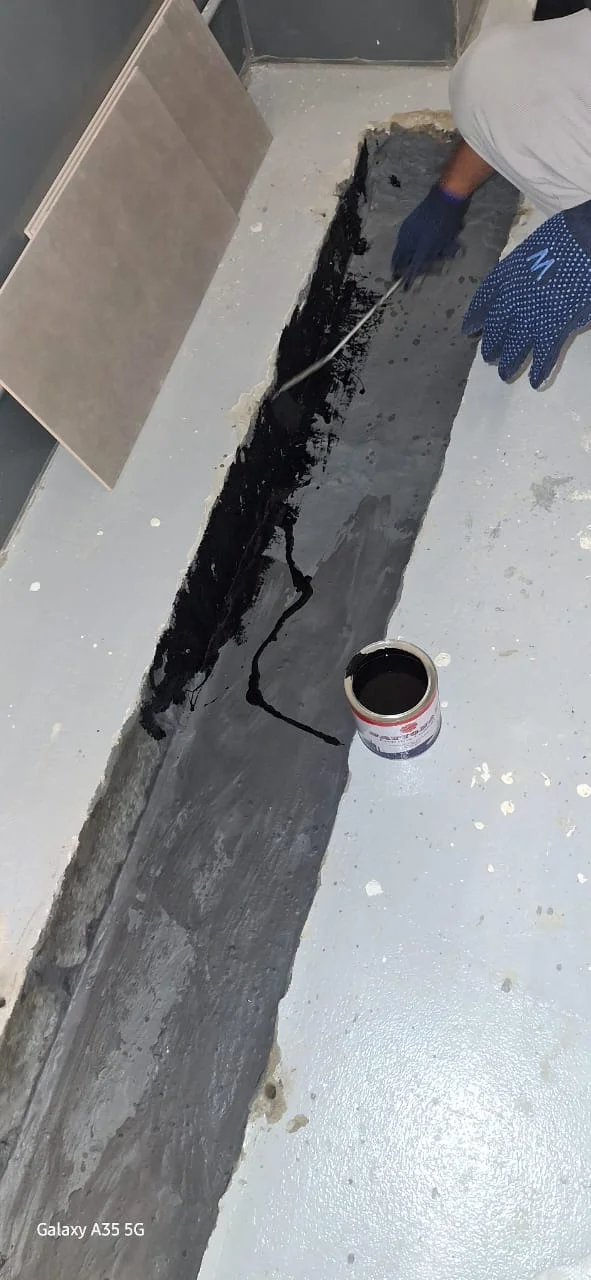 Technician applying waterproofing material along an exposed surface in Dubai
