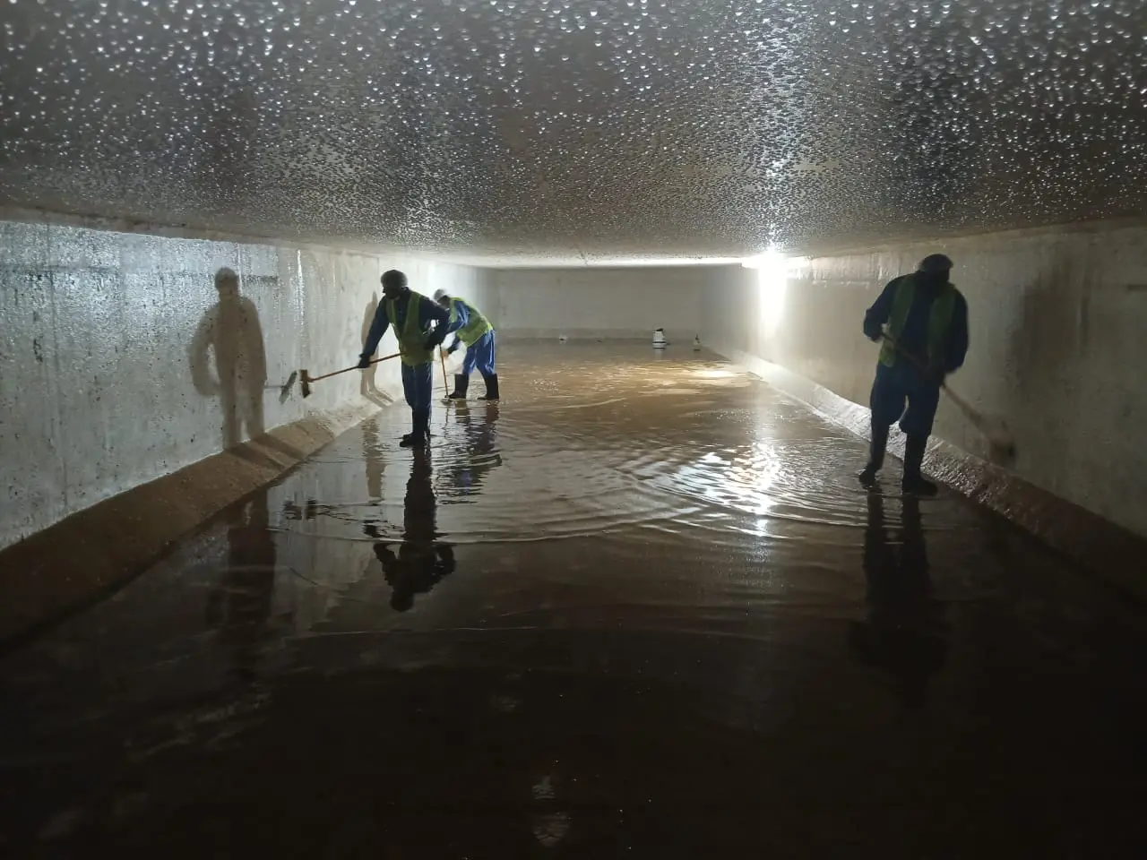 Cleaning team working inside a large water tank in Dubai