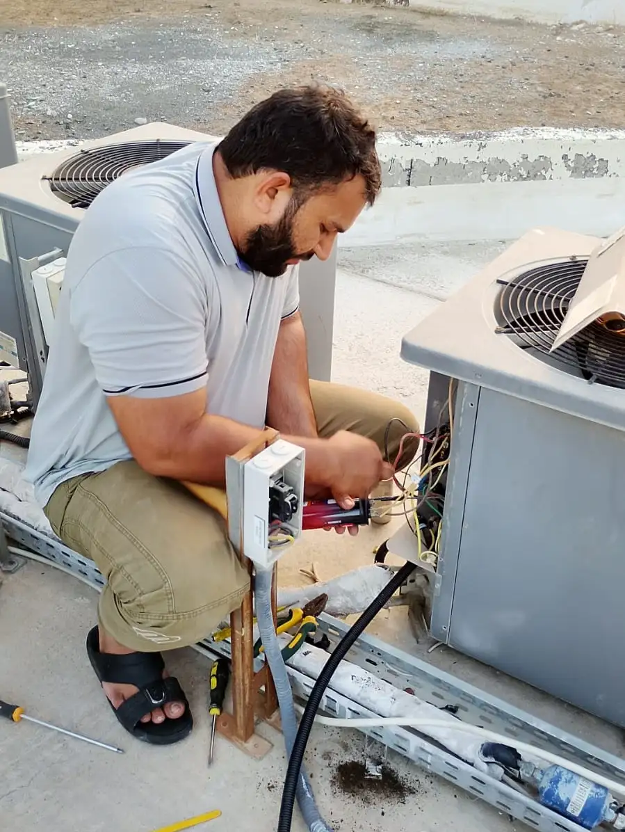Technician carrying out air conditioning maintenance at a Dubai property